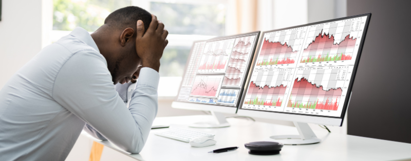 stressed person looking at line graphs trending down