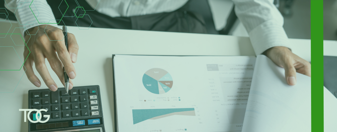 Business man pouring over charts and working on a calculator.