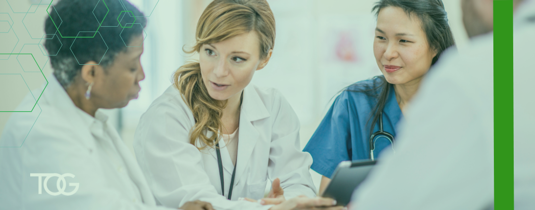 Four doctors sitting around a table having a thoughtful discussion.